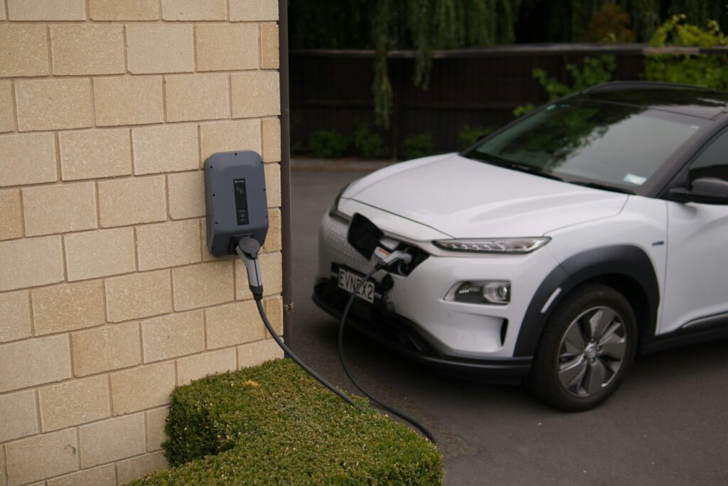 Elektrische auto laadt op bij een laadpaal aan een bakstenen muur