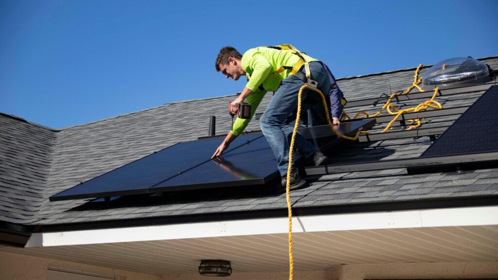 Installateur plaatst zonnepanelen op het dak van een woning