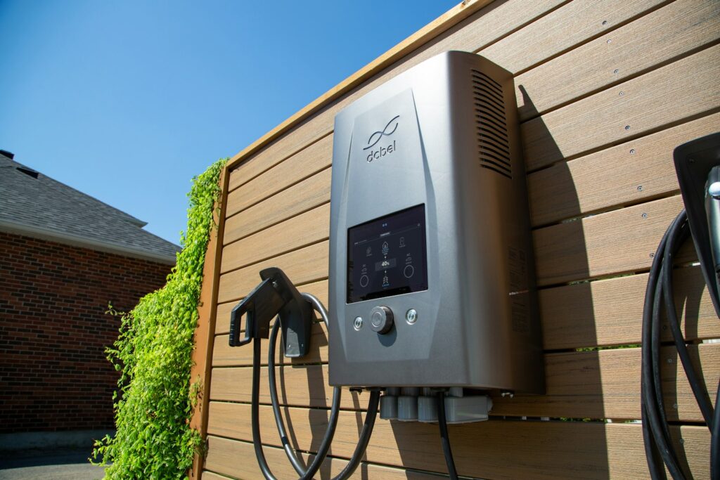 Strak vormgegeven thuisbatterij aan een houten wand in huis
