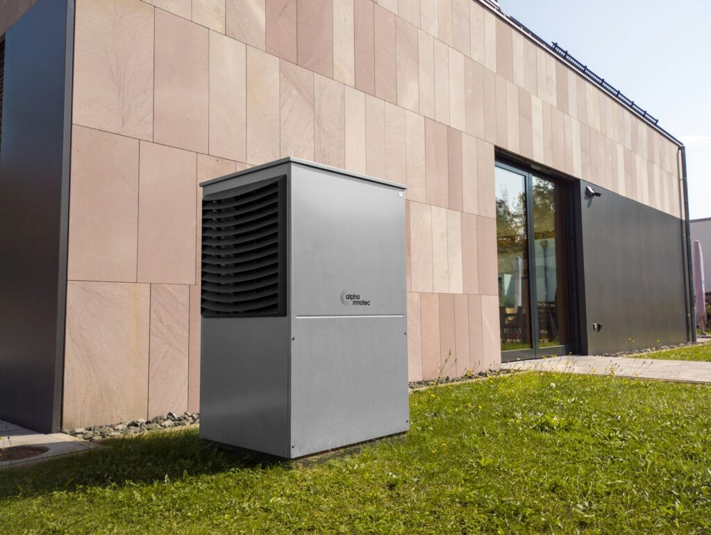 Moderne lucht-waterwarmtepomp in de tuin van een energiezuinige woning