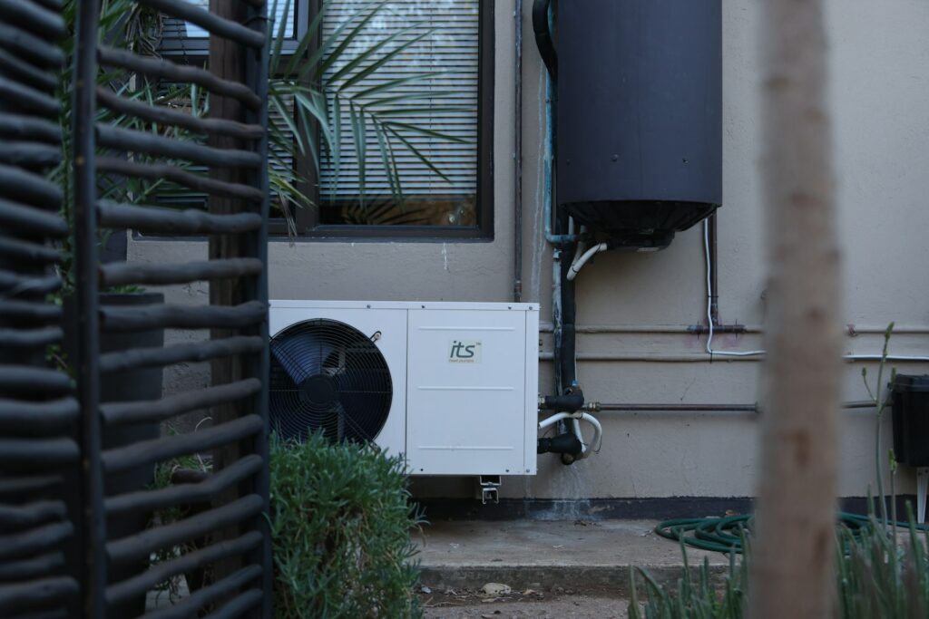 Buitenunit van een warmtepomp aan de muur van een woning