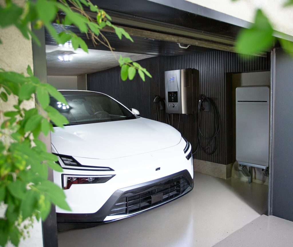 Elektrische auto in een garage met een geïntegreerd thuis-energiesysteem aan de muur